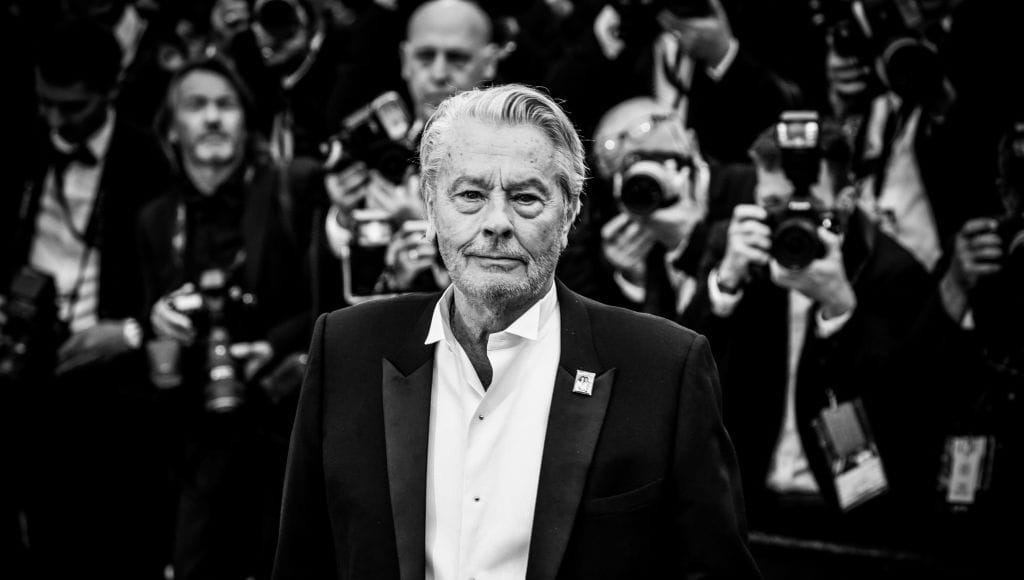 Alain Delon posant devant des photographes