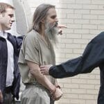 affiche Brian David Mitchell menotté et accompagné par des policiers