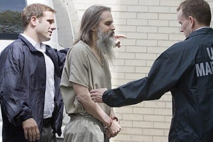 affiche Brian David Mitchell menotté et accompagné par des policiers