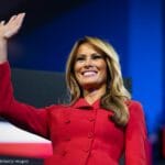 Femme en rouge saluant la foule.