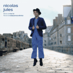 Nicolas Jules, flottant dans une rue pavée.