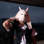 Mazu No portant une cagoule rose à cornes sur un toit, direction artistique du single Hotline