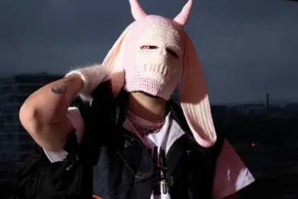 Mazu No portant une cagoule rose à cornes sur un toit, direction artistique du single Hotline