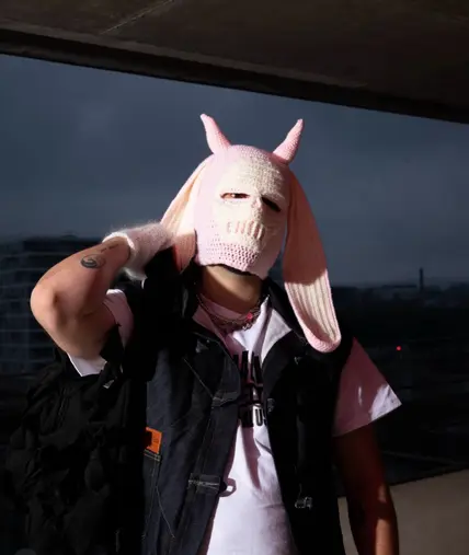 Mazu No portant une cagoule rose à cornes sur un toit, direction artistique du single Hotline